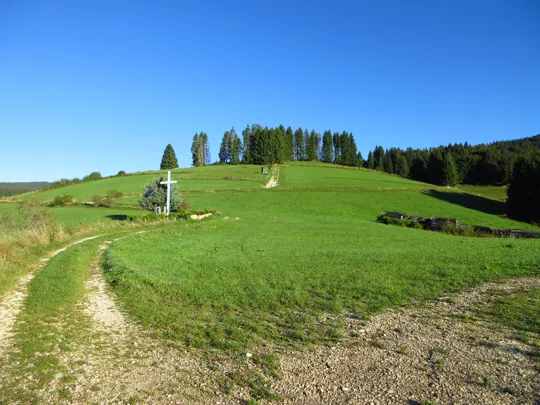 Dettaglio della strada verso la croce e gli abeti